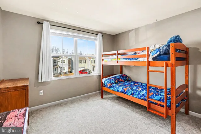 a bedroom with baby crib and a window