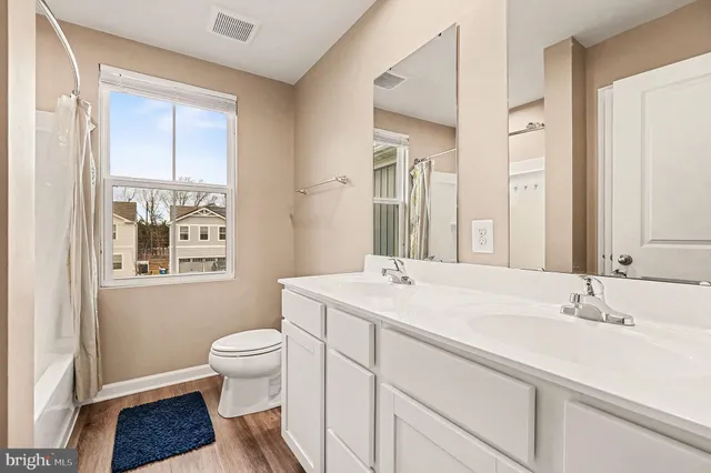 a bathroom with a sink a toilet and a large mirror