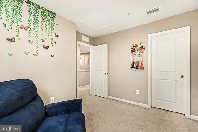 a living room with furniture and a white refrigerator