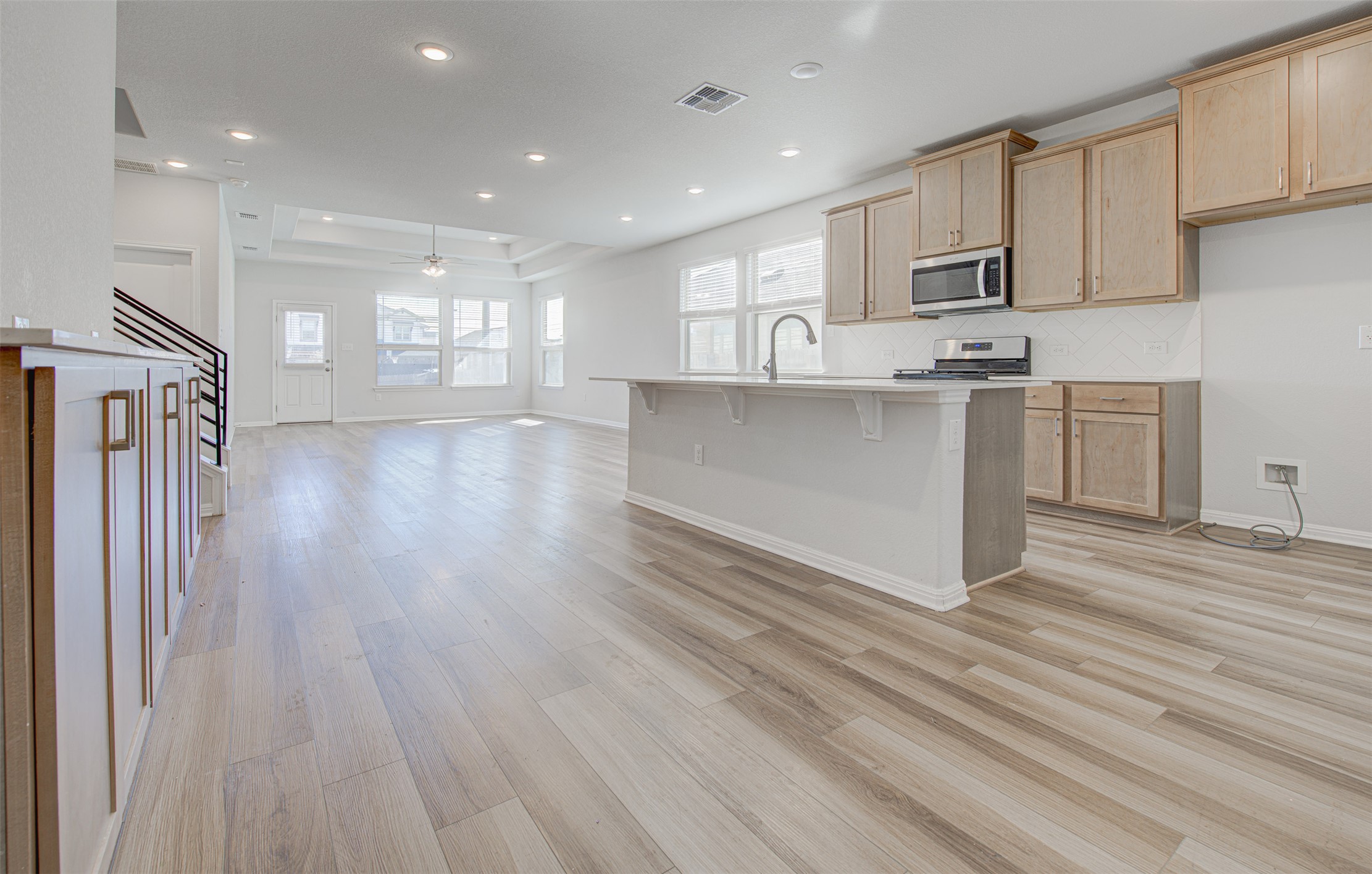13129 Ditka Drive Manchaca, TX 78652 - Photo 31 of 32 Kitchen with open floor plan, a breakfast bar, stainless steel appliances, light wood finished floors, and recessed lighting
