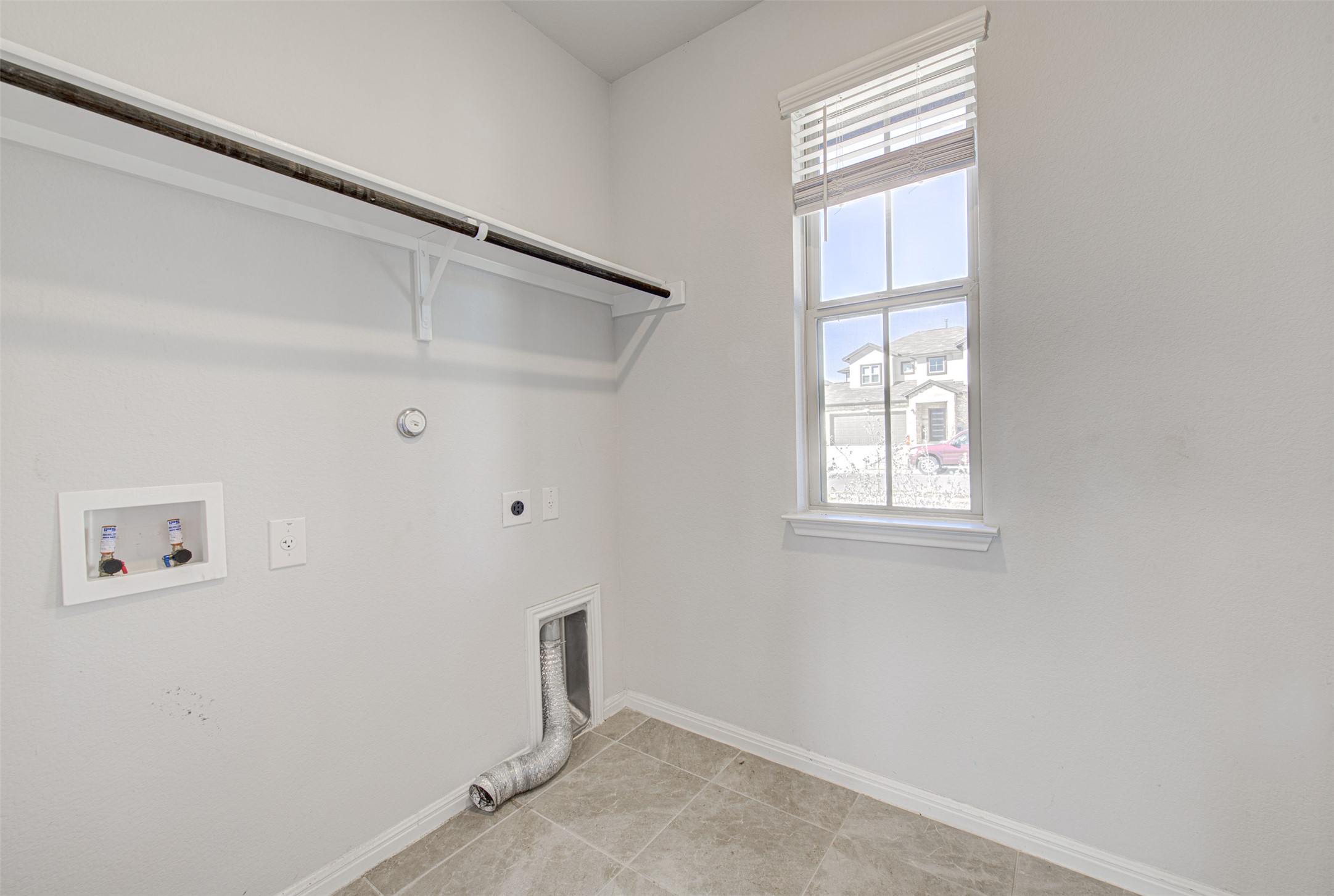 13129 Ditka Drive Manchaca, TX 78652 - Photo 7 of 32 Laundry room featuring gas dryer hookup, electric dryer hookup, washer hookup, and light tile patterned floors