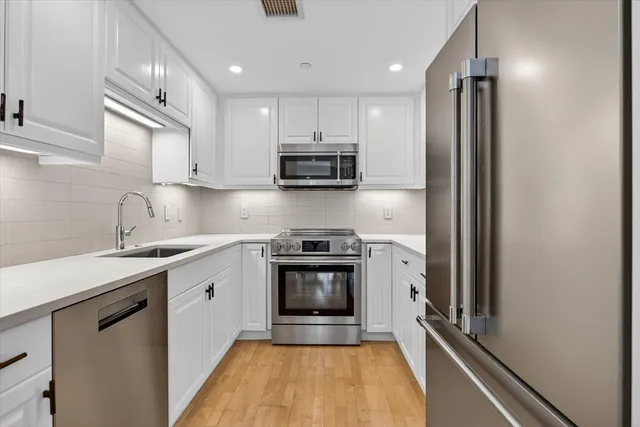 a kitchen with stainless steel appliances granite countertop a sink stove and refrigerator
