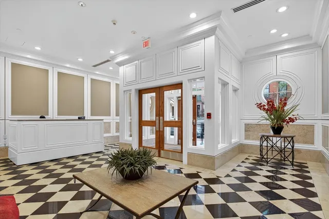 a room with lots of white furniture and wooden floor