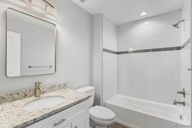 a bathroom with a granite countertop sink toilet and shower