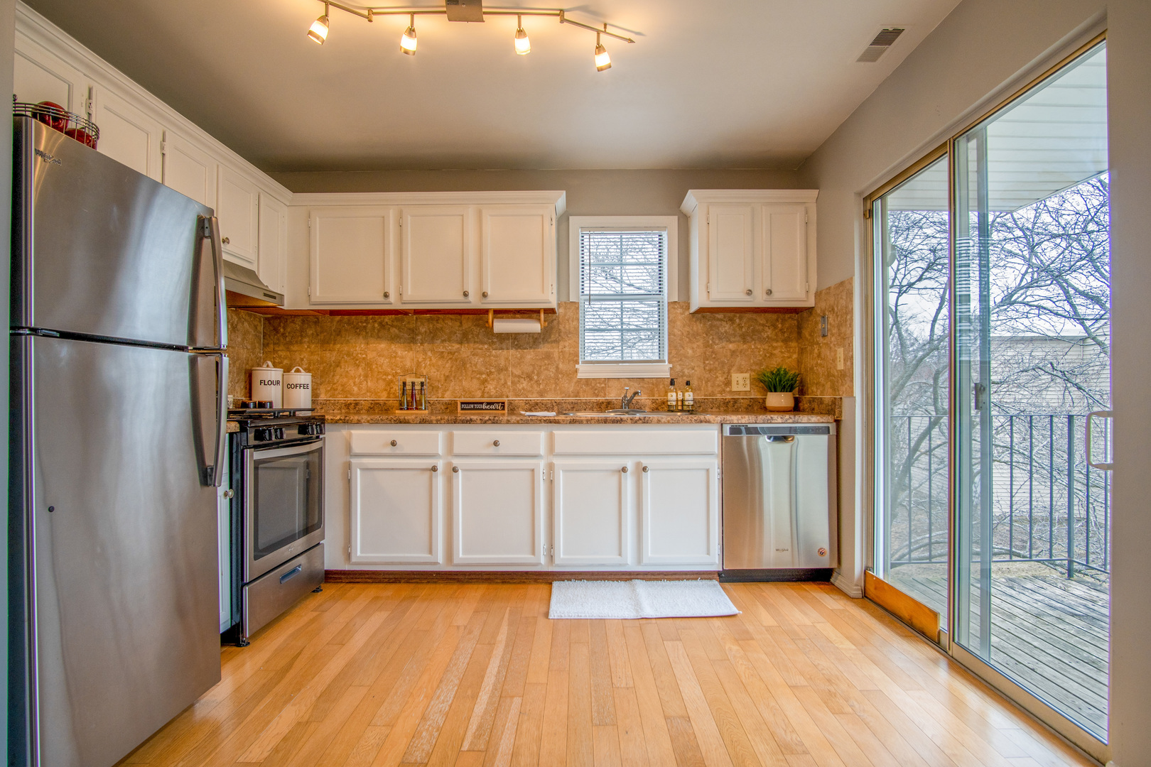 15 Gant Circle, Unit E Streamwood, IL 60107 - Photo 5 of 21 a kitchen with granite countertop a refrigerator oven a sink and white cabinets