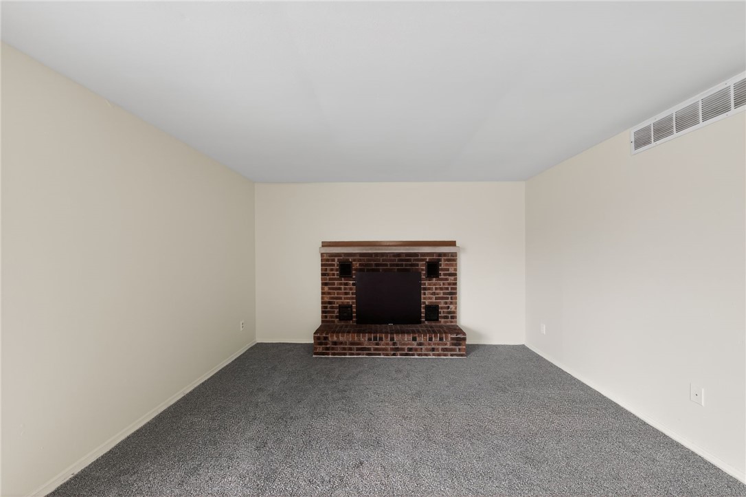 6070 Charlesgate Road Huber Heights, OH 45424 - Photo 13 of 29 This inviting room features a brick fireplace, offering warmth and character to the living space.