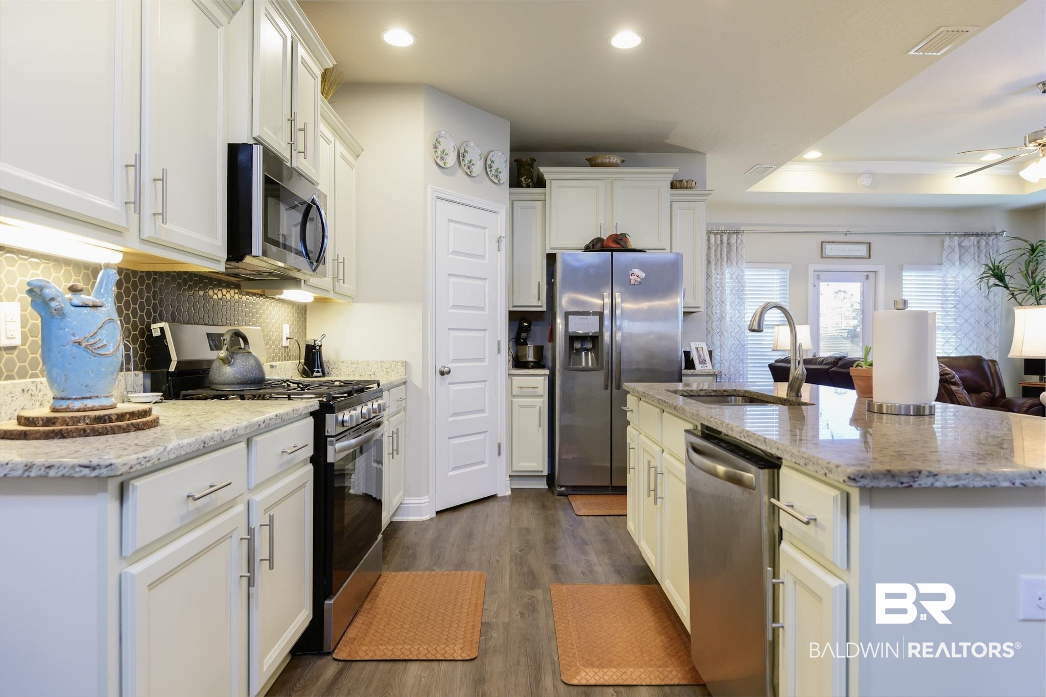 31751 Kestrel Loop Daphne, AL 36527 - Photo 10 of 21 Kitchen featuring stainless steel appliances, white cabinetry, an island with sink, recessed lighting, and light stone countertops