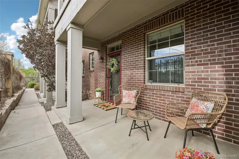 a view of a patio with couple of chairs and a potted plant