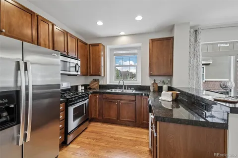 a kitchen with stainless steel appliances granite countertop a sink stove and refrigerator