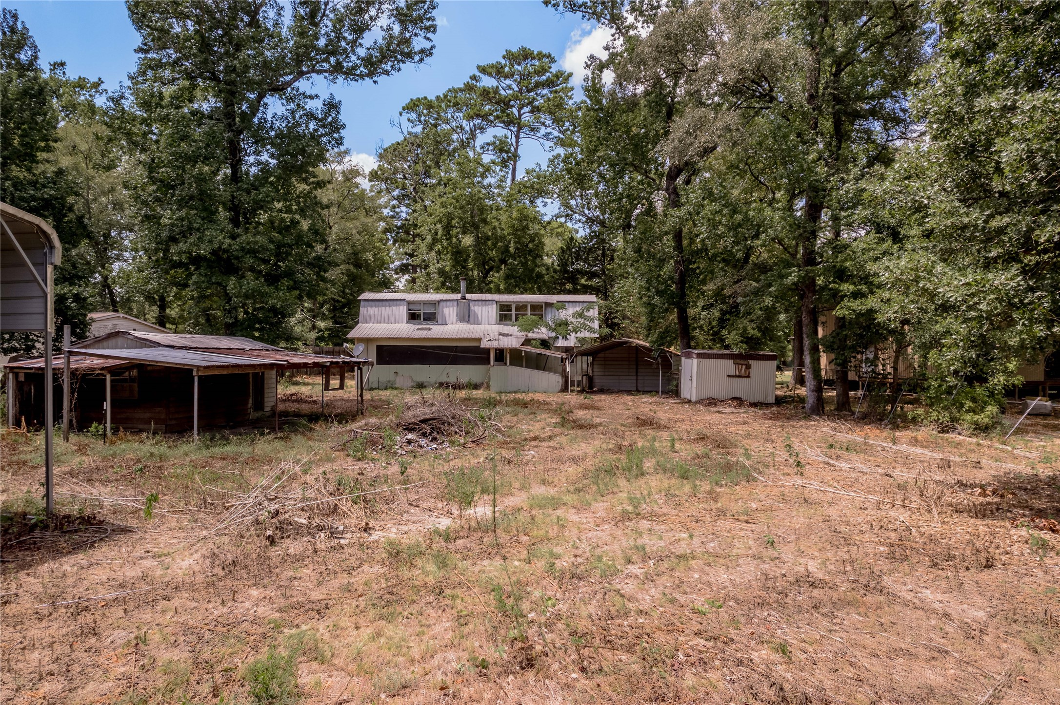 8 Creek Road Huntsville, TX 77320 - Photo 38 of 50 View of the back of the home. There are outbuildings as well.