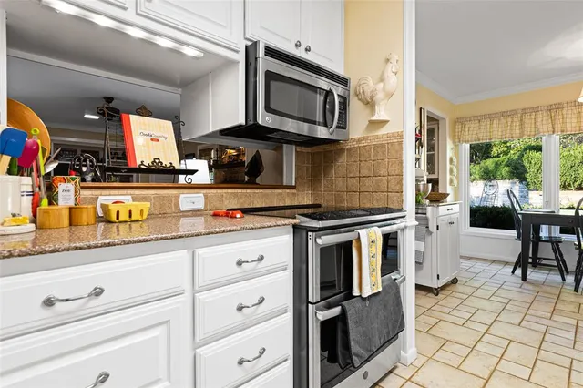 a kitchen with stainless steel appliances kitchen island granite countertop a refrigerator and a sink