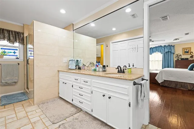 a bathroom with a granite countertop sink mirror and shower