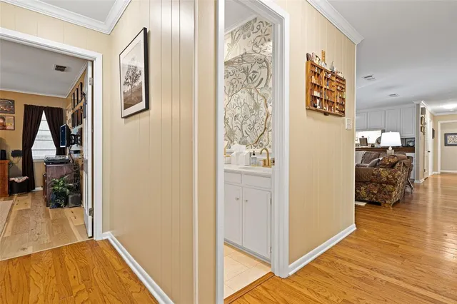 a view of a hallway with wooden floor and staircase