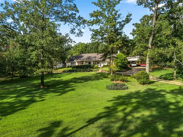 an aerial view of residential houses with outdoor space and trees