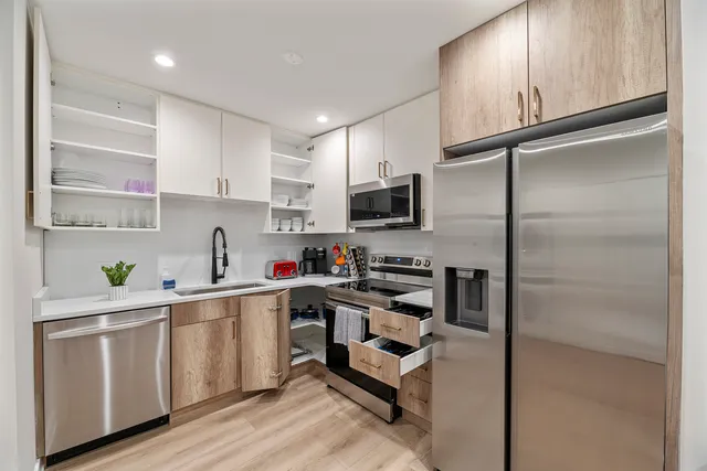 a kitchen with a refrigerator a sink and white cabinets