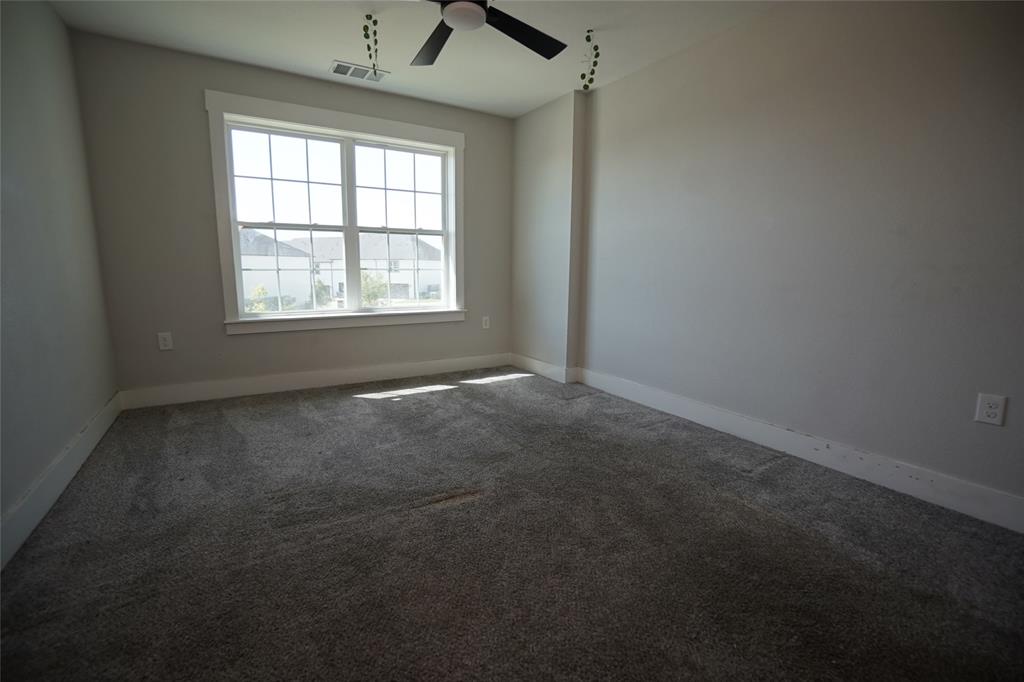 1764 Palladio Loop Princeton, TX 75407 - Photo 19 of 40 Carpeted room featuring a large window with grid panes, white trim, and a ceiling fan