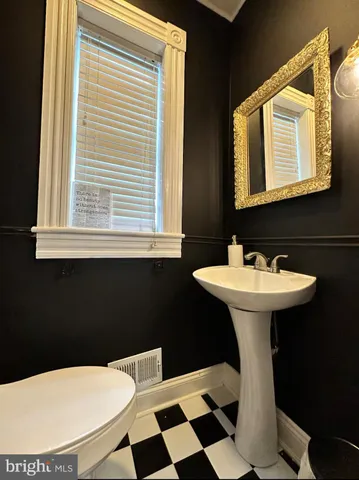 a bathroom with a sink a toilet a mirror and shower