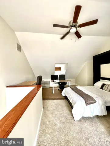 a bed room with a bed and a ceiling fan