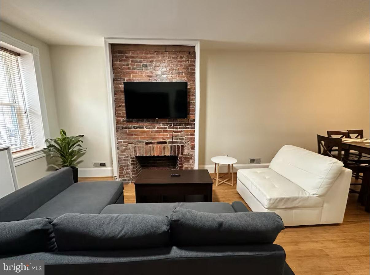 2112 Cambridge Street Baltimore, MD 21231 - Photo 4 of 20 a living room with furniture a flat screen tv and a fireplace