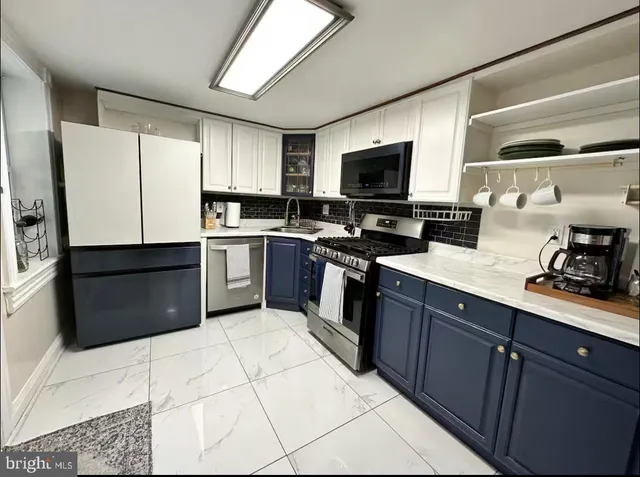 a kitchen with stainless steel appliances granite countertop a stove top oven a sink dishwasher a refrigerator and a microwave