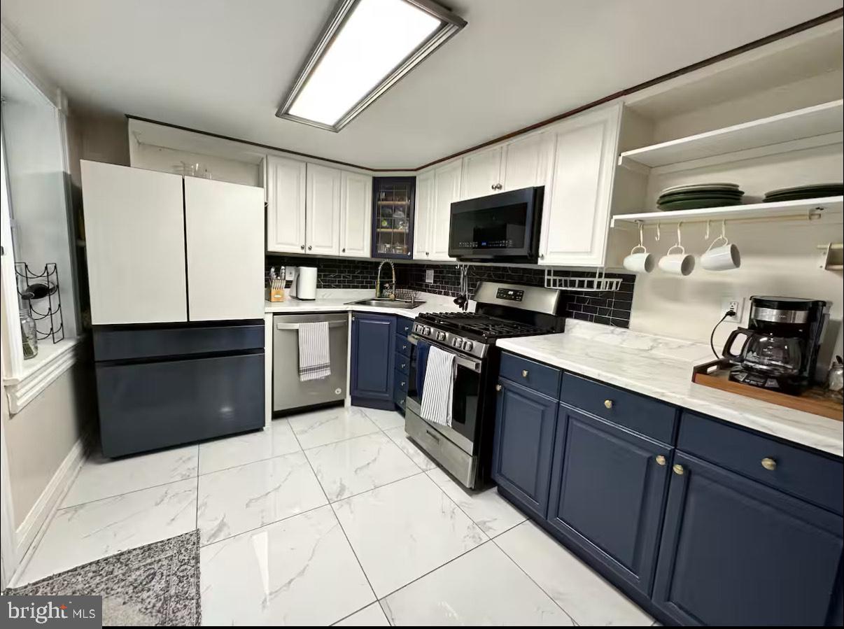 2112 Cambridge Street Baltimore, MD 21231 - Photo 9 of 20 a kitchen with stainless steel appliances granite countertop a stove top oven a sink dishwasher a refrigerator and a microwave