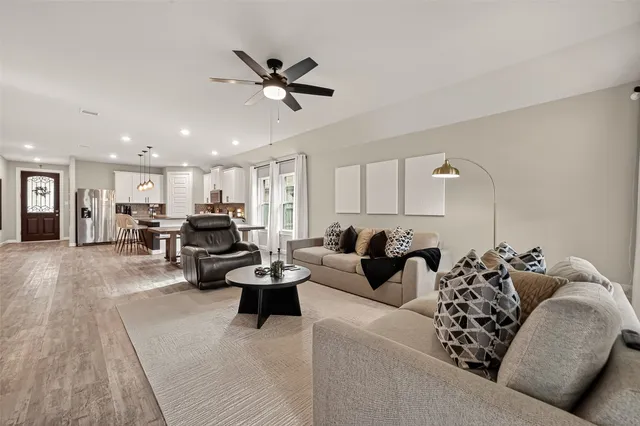 a living room with furniture and a view of kitchen