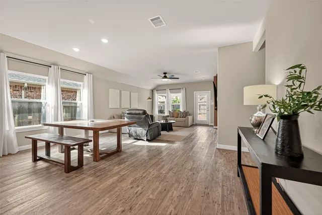 a living room with furniture a potted plant and open windows