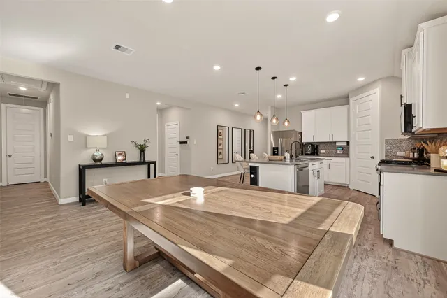 a large kitchen with kitchen island a stove a refrigerator a sink a dining table and chairs