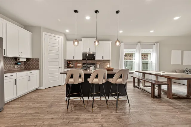 a kitchen with stainless steel appliances kitchen island granite countertop a stove a refrigerator a sink and a oven