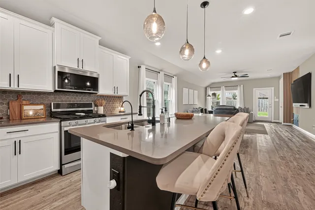 a kitchen with a sink appliances and a wooden floor