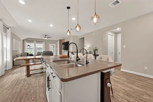 a kitchen with a sink a stove cabinets and wooden floor