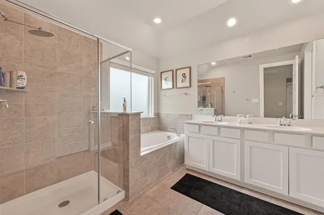 a bathroom with a tub a sink and mirror