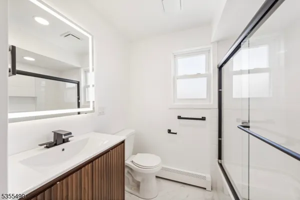 a bathroom with a sink a toilet and a mirror