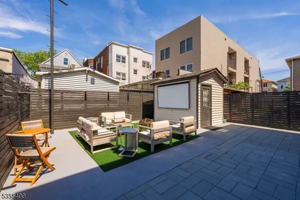 a view of a patio with table and chairs with wooden floor and fence