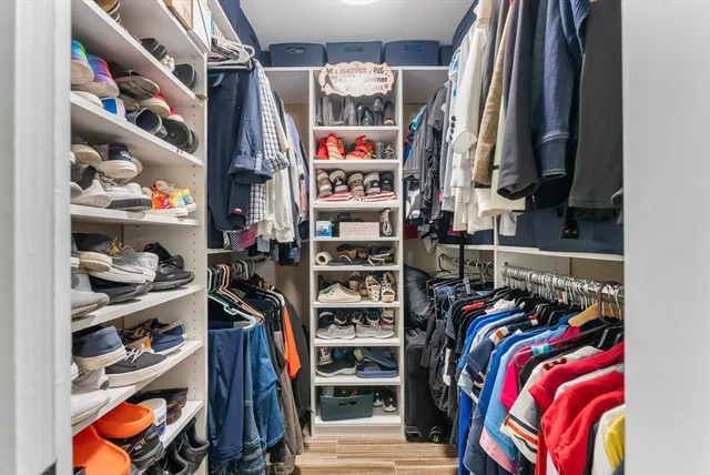 a bedroom with a bed and a flat tv screen on dresser