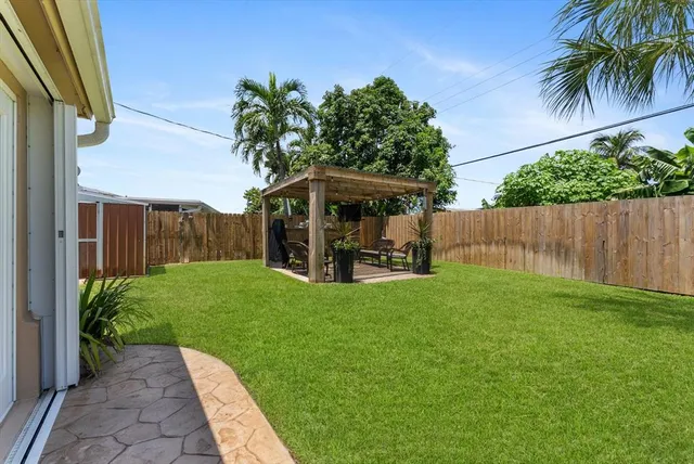 a view of a backyard with table and chairs and a barbeque