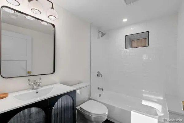 a bathroom with a toilet a sink and mirror