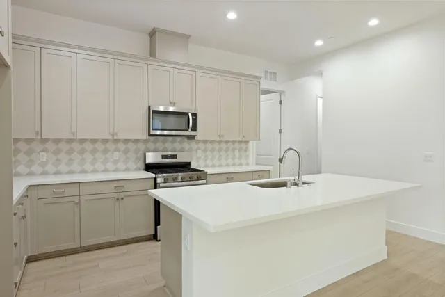 a kitchen with a sink a stove and cabinets