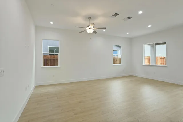 an empty room with fan and windows