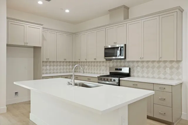a kitchen with sink a microwave and cabinets