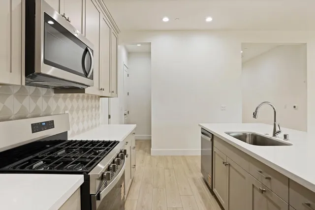 a kitchen with granite countertop a sink stove and cabinets