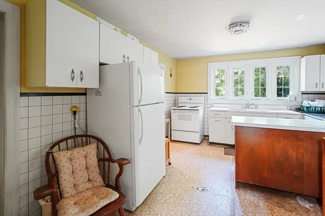 a kitchen with white cabinets and white appliances