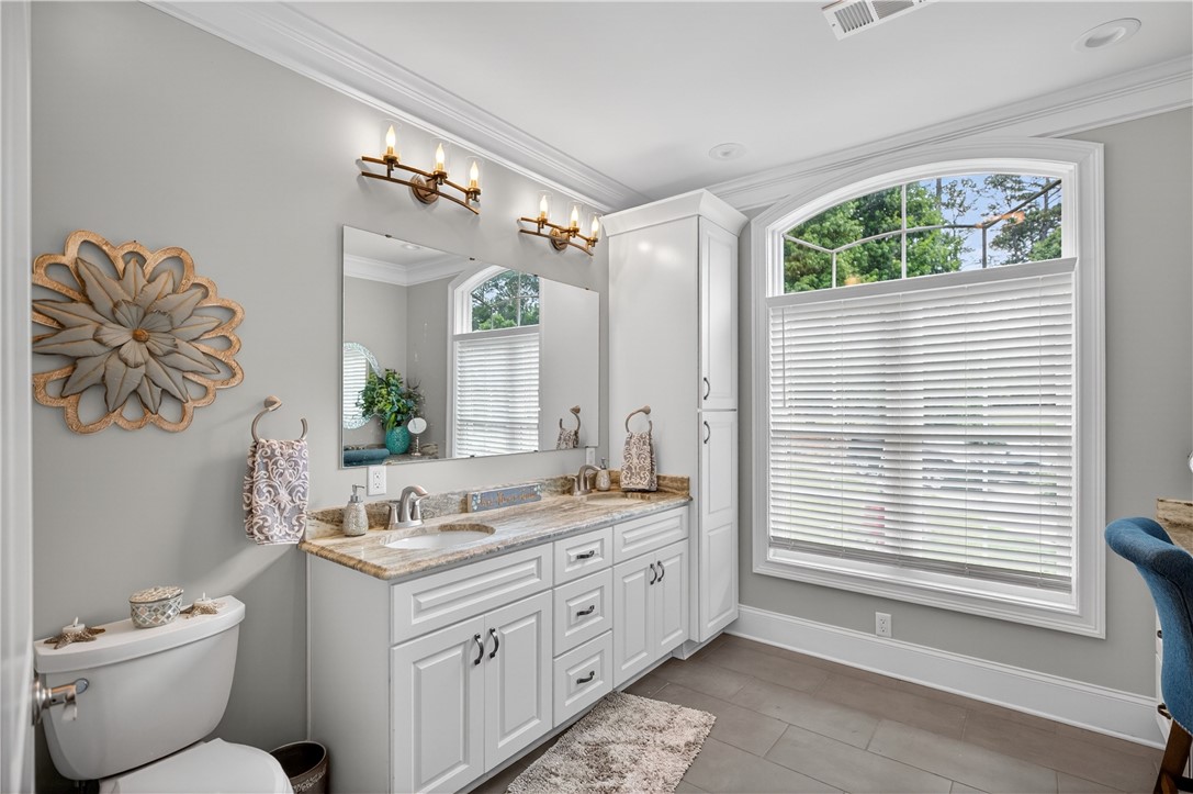 206 James Hare Road Anderson, SC 29626 - Photo 34 of 37 A well-appointed primary bathroom showcases a large vanity with ample storage and an elegant arched window.