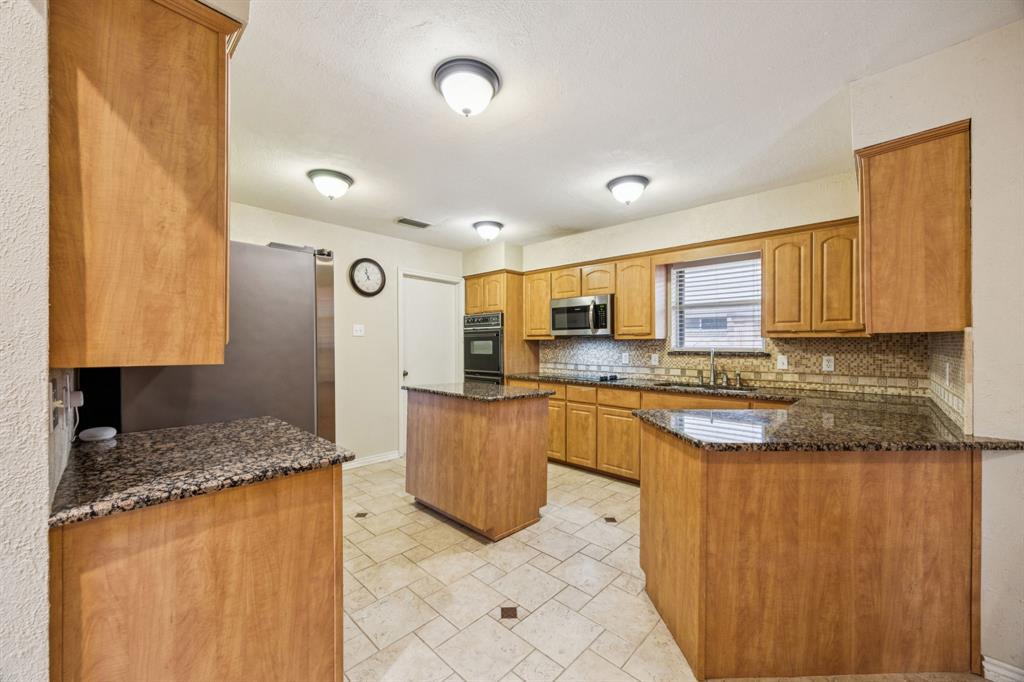 314 Amherst Avenue Richardson, TX 75081 - Photo 15 of 38 a large kitchen with granite countertop a sink and cabinets