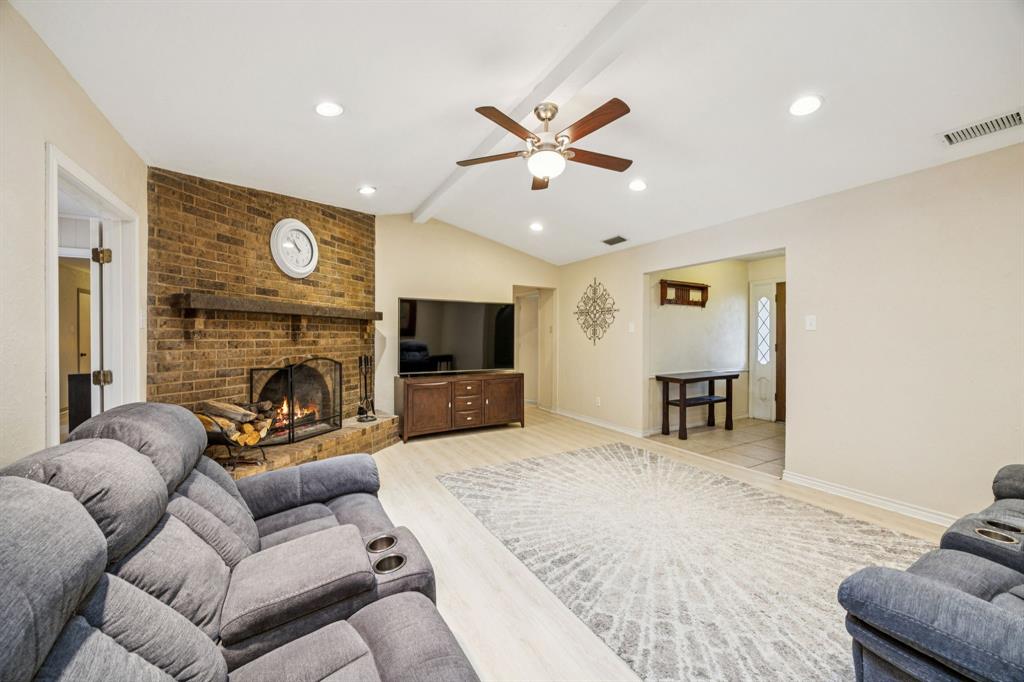 314 Amherst Avenue Richardson, TX 75081 - Photo 8 of 38 a living room with furniture a flat screen tv and a fireplace