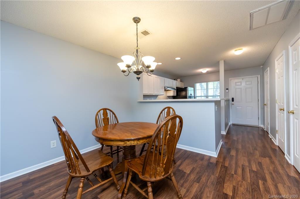 8312 Rudolph Road Charlotte, NC 28216 - Photo 14 of 37 a dining room filled chandelier and wooden floor