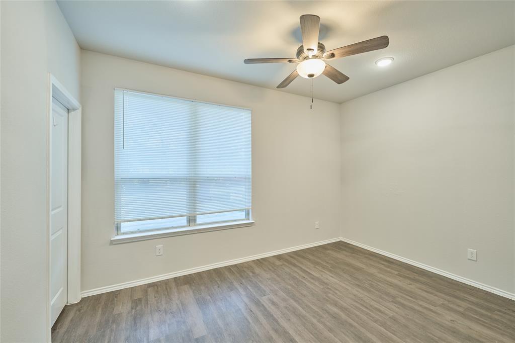 9992 Calendar Street Willis, TX 77318 - Photo 11 of 25 an empty room with wooden floor fan and windows