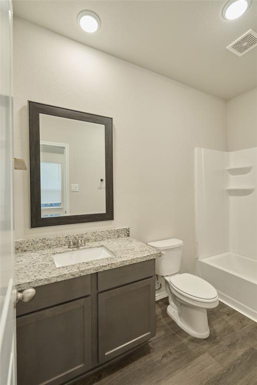 9992 Calendar Street Willis, TX 77318 - Photo 18 of 25 a bathroom with a granite countertop toilet a sink and a mirror