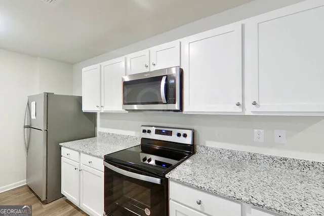 a kitchen with white cabinets and stainless steel appliances