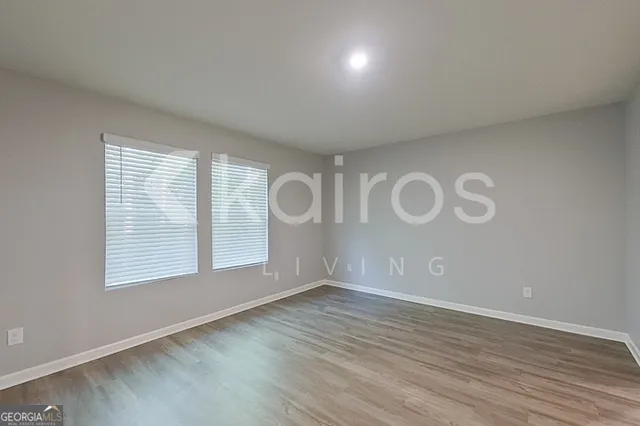an empty room with wooden floor and window